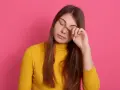 Dziewczyna z opuchniętymi oczami, która pociera powieki, szuka rozwiązania co na opuchnięte oczy.