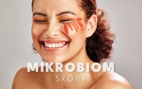 Uśmiechnięta kobieta z płatkami kwiatów na policzku. Tekst: "MIKROBIOM SKÓRY".