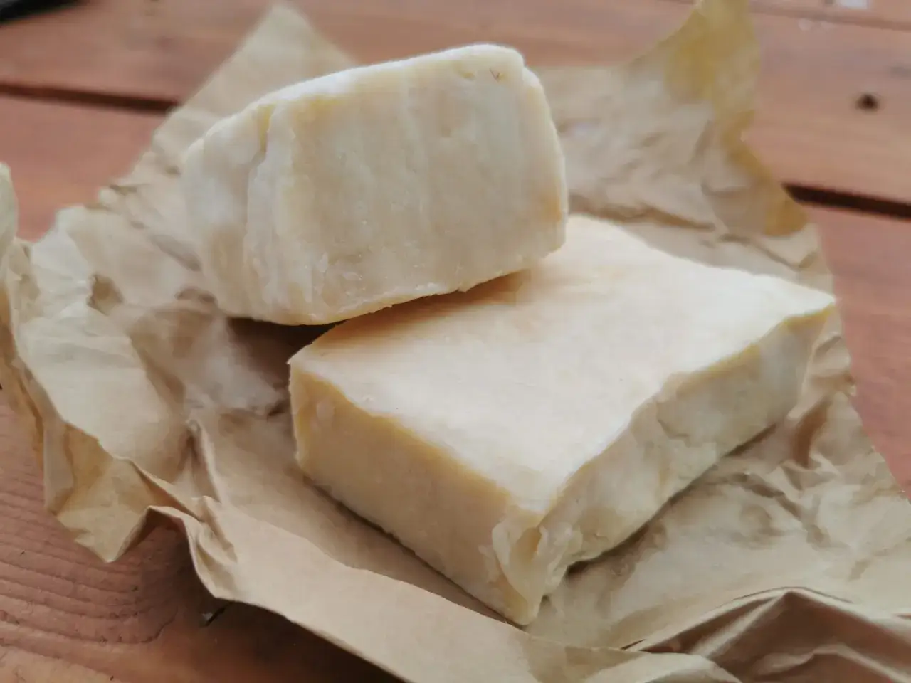 Dwa kawałki szarego mydła na brązowym papierze. Szare mydło na co pomaga? Na wszystko!